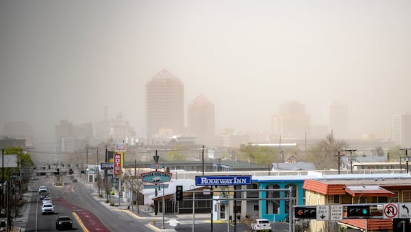 Travel is highly discouraged in the #ABQ metro through Tuesday afternoon, March 18, 2025, due to visibility below a quarter mile from blowing dust and dangerous crosswinds of up to 70 mph on north to south roads and highways, in downtown Albuquerque, N.M., looking west from Route 66. (AP Photo/Roberto E. Rosales)