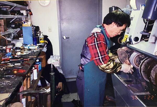 Chun-ki Kim is seen working inside his shoe shop.