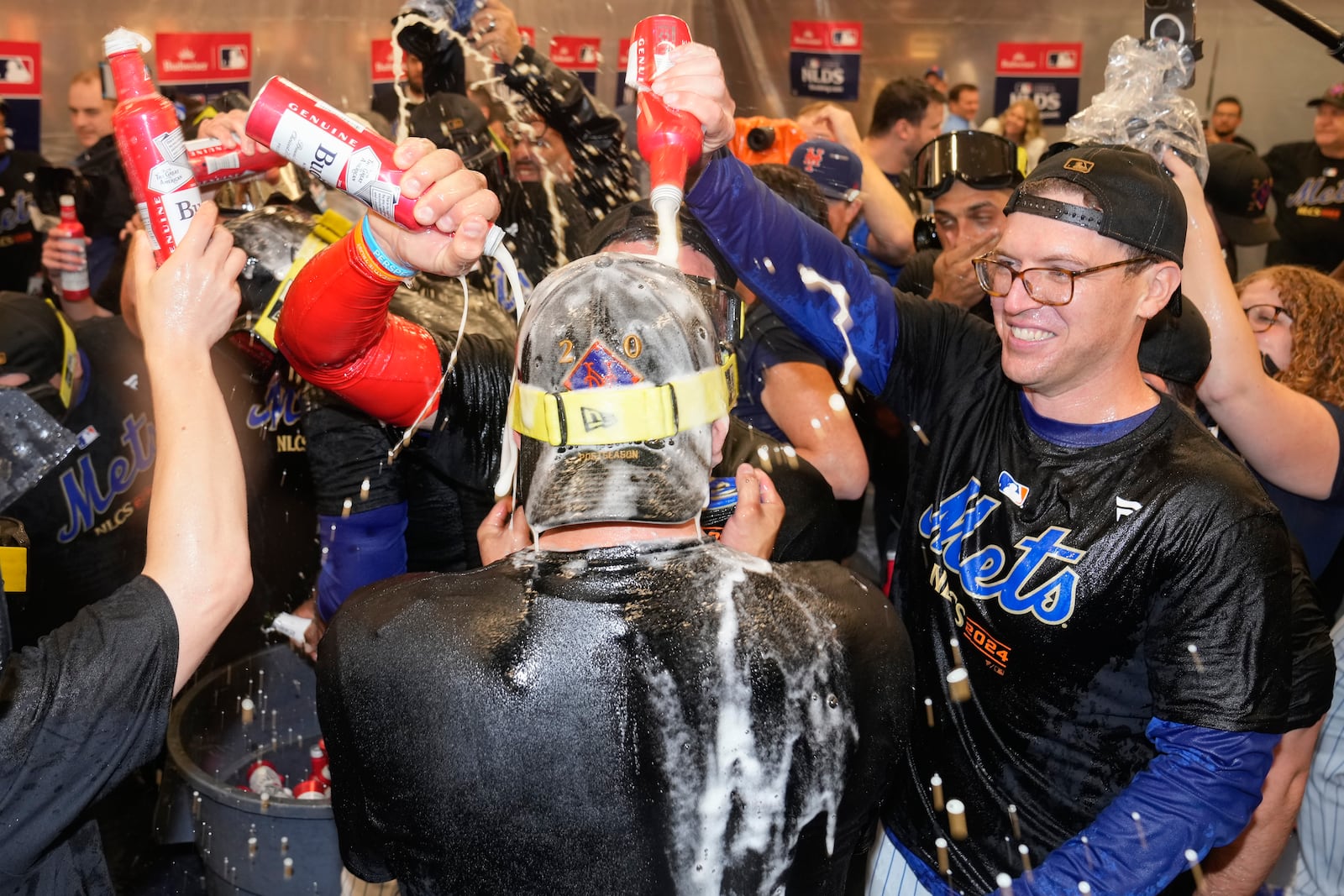 The New York Mets celebrate in the locker room after defeating the Philadelphia Phillies in Game 4 of the National League baseball playoff series, Wednesday, Oct. 9, 2024, in New York. (AP Photo/Frank Franklin II)