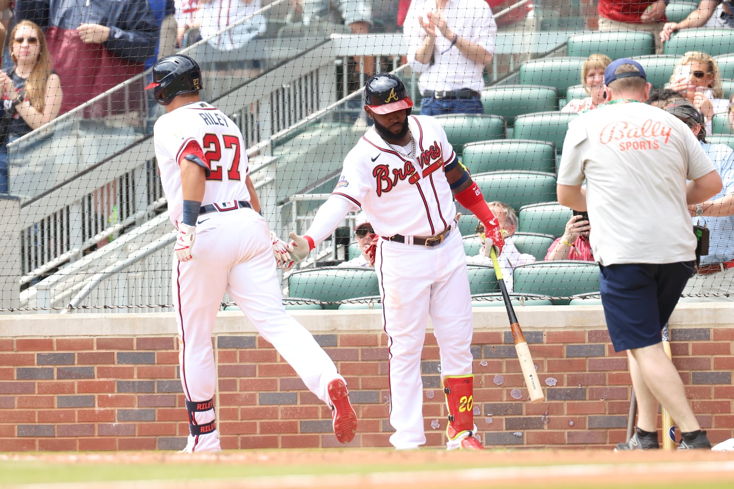 Braves third baseman Austin Riley (27) shakes hands with Marcell Ozuna after scoring Atlanta's first run in the bottom of the sixth inning Wednesday at Truist Park. (Miguel Martinez/miguel.martinezjimenez@ajc.com)