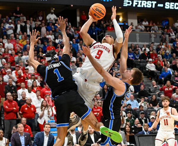 Wisconsin guard John Tonje (9) goes up for a basket as BYU guards Trey Stewart, left, and Egor Demin, front right, defend during the second half in the second round of the NCAA college basketball tournament Saturday, March 22, 2025, in Denver. (AP Photo/John Leyba)