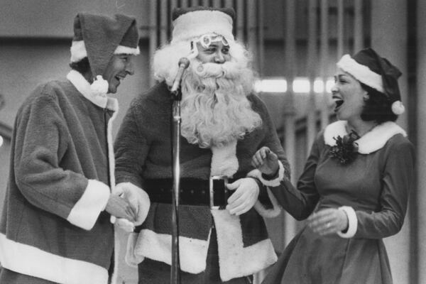 In 1981, U.S. Congressman Wyche Fowler plays Santa's helper, Atlanta Mayor Maynard Jackson plays Santa Claus, and as an elf, Jackson's wife Valerie offers an assist. (Jerome McClendon/AJC 1981 photo)