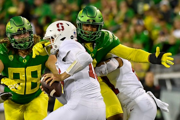 FILE - Oregon defensive end Brandon Dorlus (3) sacks Stanford quarterback Tanner McKee (18) as defensive lineman Casey Rogers (98) comes in on the play during the second half of an NCAA college football game Saturday, Oct. 1, 2022, in Eugene, Ore. Oregon opens their season at home against Portland State on Sept. 2. (AP Photo/Andy Nelson, File)