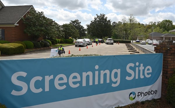 Medical workers give instructions at a Phoebe Putney Health System drive-through testing site in Albany. (Hyosub Shin / Hyosub.Shin@ajc.com)