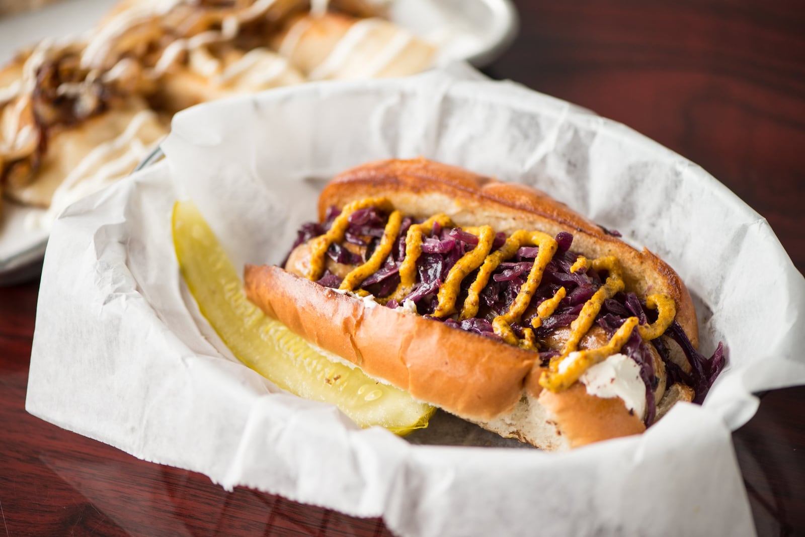 Bratwurst with cream cheese, braised red cabbage, and mustard. Photo credit- Mia Yakel.