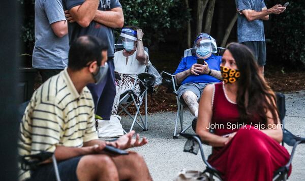 Munis Lukman, Florence LeCraw, Tom Mroz and Candace Tucker wait for the polls to open at the Park Tavern voting precinct at Piedmont Park in Atlanta.