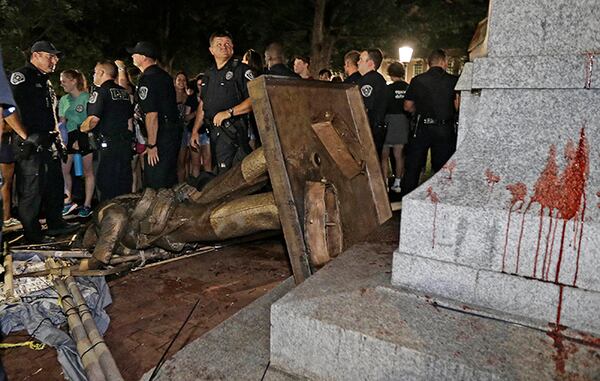 Police stand guard after the Confederate statue known as Silent Sam was toppled by protesters on campus at the University of North Carolina in Chapel Hill.