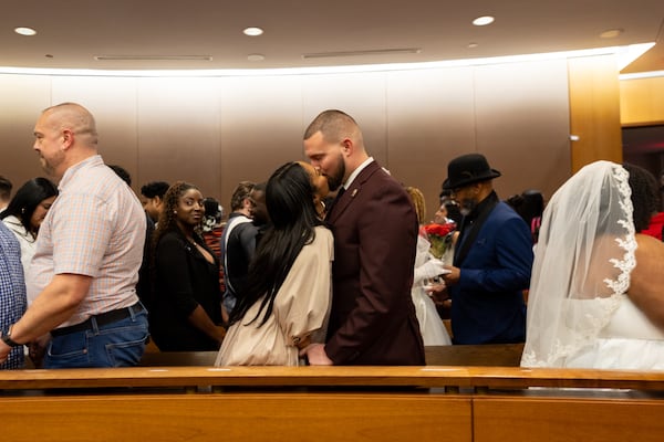 (Center L-R) Kierah and Jacob Sealand kiss during a group Valentine’s Day wedding at Fulton County Courthouse in Atlanta on Friday, February 14, 2025. (Arvin Temkar / AJC)