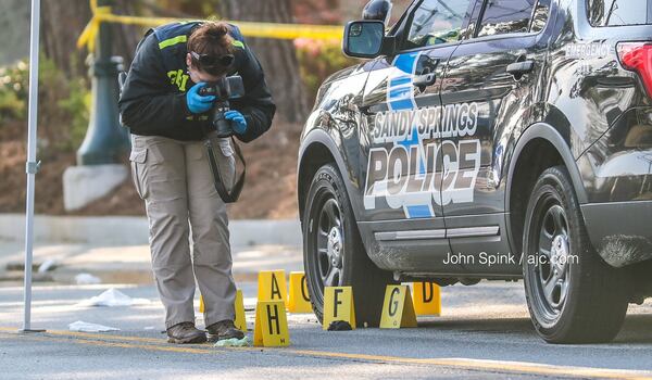 A GBI agent photographs evidence at the scene of an officer-involved shooting in Sandy Springs. JOHN SPINK / JSPINK@AJC.COM