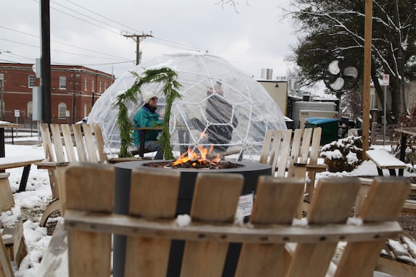 People eat outside at Bad Luck Burger Club after snow fell in the area in Nashville, Tenn. on Saturday, Jan.11, 2025. (AP Photo/Kristin M. Hall)