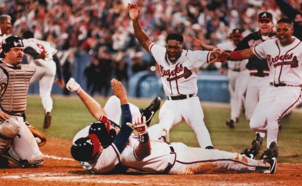 Sid Bream, prone on the ground, gets mobbed by teammates after scoring the winning run in Game 7 of the 1992 NLCS.