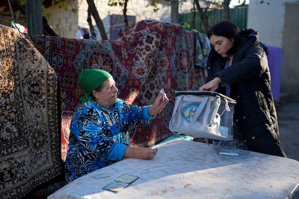 A woman casts her vote in a mobile ballot box during a presidential election runoff, in the village of Ciopleni, Moldova, Sunday, Nov. 3, 2024. (AP Photo/Vadim Ghirda)