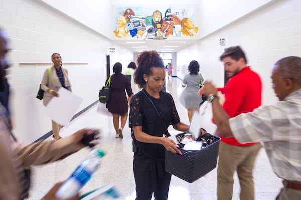 Katoria Gaston, an instructional coach for staff development, collects badges as Gwinnett County Public Schools educators leave a new teacher orientation at Peachtree Ridge High School in Suwanee, Ga., on Wednesday, July 17, 2019. (Casey Sykes for The Atlanta Journal-Constitution)