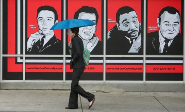 Christa Tinsley walks past the Laughing Skull Lounge in Midtown Atlanta while rain starts to fall on the area. Heavy fog early in the week has given way to a pair of weather systems that are expected to dump 3-4 inches of rain through Sunday. Yes, the posters on the wall are of Lenny Bruce, Mort Sahl , Dick Gregory and Jonathan Winters. No, they're not likely to perform at the comedy venue.