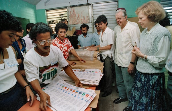 Former U.S. President Jimmy Carter and his wife, Rosalynn (right), watch election workers prepare ballots at a polling station in Managua, Nicaragua, on Feb. 25, 1990. (J. Scott Applewhite/AP)