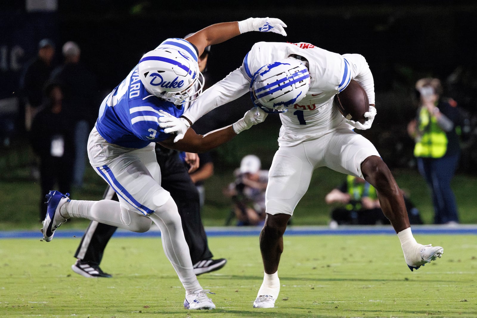 SMU's Brashard Smith (1) carries the ball as Duke's Alex Howard (3) grabs his helmet during the first half of an NCAA college football game in Durham, N.C., Saturday, Oct. 26, 2024. (AP Photo/Ben McKeown)