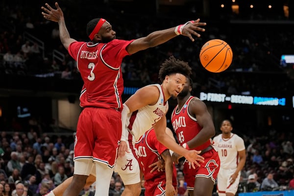 Alabama guard Mark Sears, center, passes in front of Robert Morris guard Amarion Dickerson (3) in the first half in the first round of the NCAA college basketball tournament, Friday, March 21, 2025, in Cleveland. (AP Photo/Sue Ogrocki)