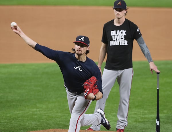 Braves NLCS Game 1 starter Max Fried (background) looks on as Game 3 starter Kyle Wright throws from the mound Sunday, Oct. 11, 2020, during the team workouts ahead of the National League Championship Series against the Los Angeles Dodgers at Globe Life Field in Arlington, Texas. (Curtis Compton / Curtis.Compton@ajc.com)