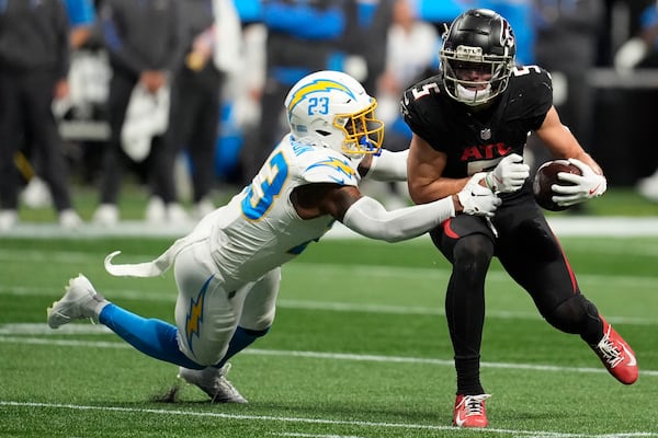 Atlanta Falcons wide receiver Drake London (5) runs the ball after making a catch against Los Angeles Chargers safety Tony Jefferson (23) during the second half of an NFL football game on Sunday, Dec. 1, 2024 in Atlanta. (AP Photo/Mike Stewart)