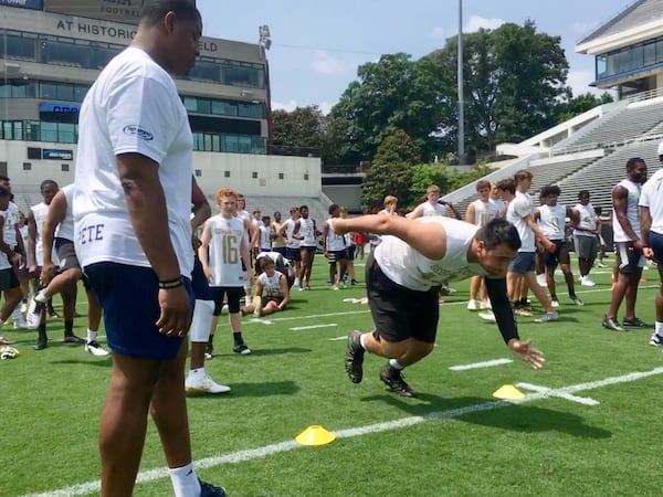 Ivan Shultz, an offensive lineman from Mobile, Ala., runs the 40-yard dash on Grant Field under the eye of Georgia Tech defensive lineman Antwan Owens at coach Geoff Collins' showcase camp Monday, June 3, 2019.