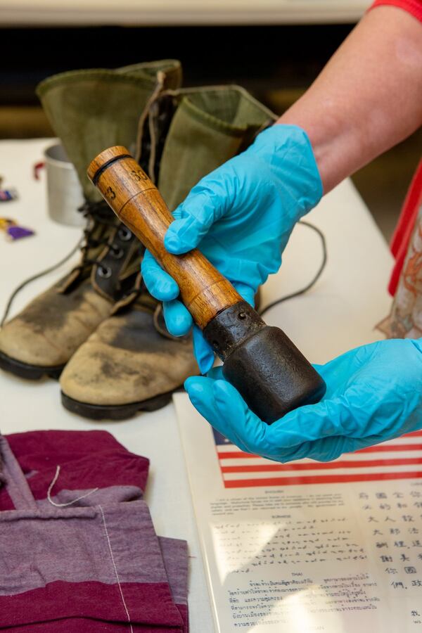 Sue VerHoef displays artifacts from the Atlanta History Center’s Veterans History Project collection. VerHoef is holding an unexploded Viet Cong hand grenade from the Vietnam War. (Photo by Phil Skinner)