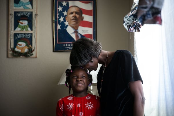 Cherry Glover, who has a developmental disability, lays her head on her daughter, Asia Glover, 7, in hopes of getting her to smile at their Atlanta home as they pose for a portrait. Glover and her four kids are one of more than 100 families in metro Atlanta that will be helped by All About Developmental Disabilities’ Adopt-a-Family program this year. BRANDEN CAMP / SPECIAL