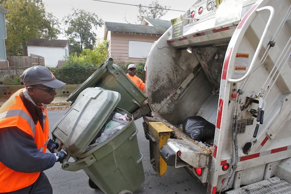 James Dent III (in back), and Derrick Shelton work a collection route in Atlanta. Bob Andres / bob.andres@ajc.com