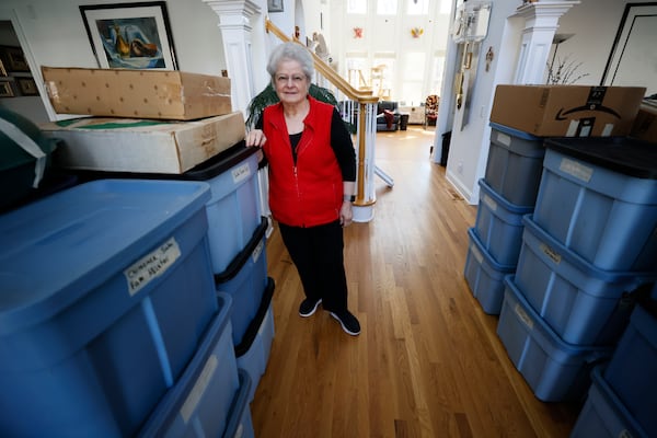 Marielos Bond poses surrounded by boxes where she stores a collection of more than 1,000 nativity scenes. By Dec. 10, she had arranged them in every corner of her Alpharetta home.
 Miguel Martinez / miguel.martinezjimenez@ajc.com