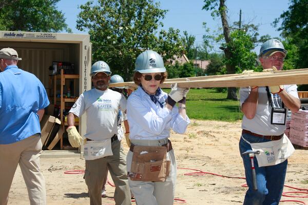 For more than three decades, Jimmy and Rosalynn Carter led annual week-long Carter Work Projects for Habitat for Humanity, a nonprofit organization that helps to build and renovate homes for those in need. Rosalynn Carter is pictured here carrying a truss in Pascagoula, Miss., in 2008. (Gregg Pachkowski / Habitat for Humanity)