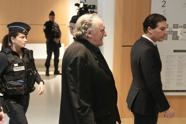 Actor Gerard Depardieu, center, who is facing trial for the alleged sexual assaults of two women on a film set in 2021, arrives with his lawyer Jeremie Assous, right, Monday, March 24, 2025 in Paris. (AP Photo/Thibault Camus)