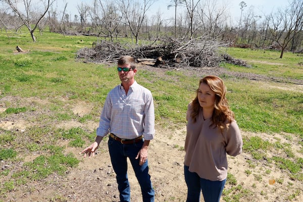 Arren Moses and his wife, Taylor Moses, co-owners of Moses Pecan Farm, stand in one of their orchards that was significantly damaged by Hurricane Helene six months ago. (Miguel Martinez/AJC)