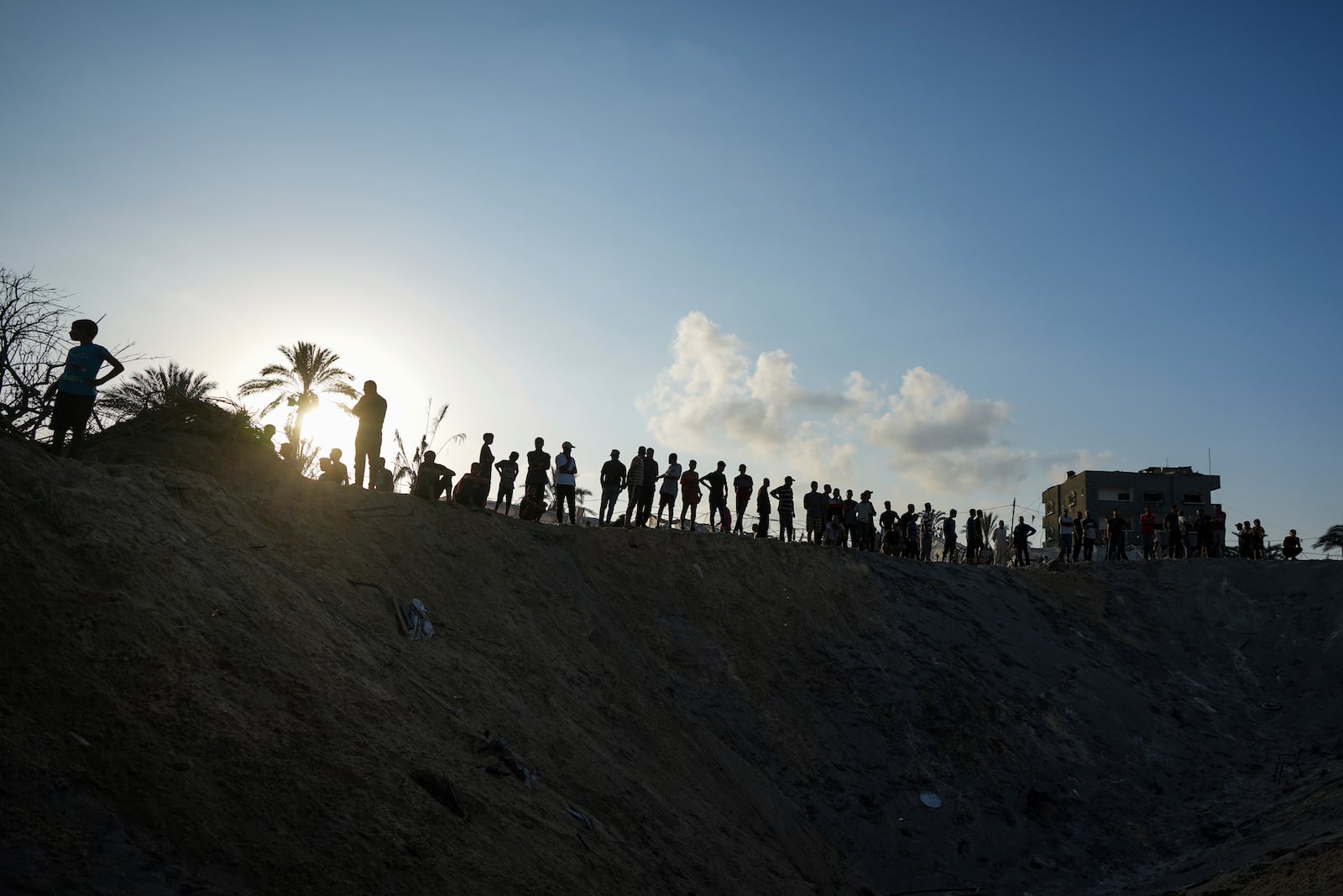 FILE - Palestinians look at the destruction after an Israeli airstrike on a crowded tent camp housing people displaced by the war in Muwasi, Gaza Strip, on Sept. 10, 2024. (AP Photo/Abdel Kareem Hana, File)