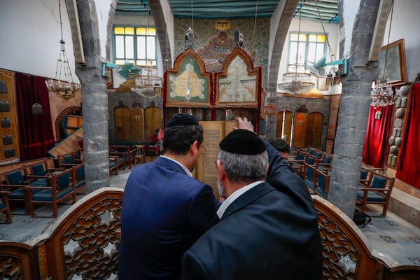 FILE - Rabbi Yusuf Hamra, right, and his son Henry lookout an old scripture at the Efranj synagogue in the old city of Damascus Feb. 18, 2025. The Syrian-American Jewish family returned for the first time since emigrating from Syria to the United States more than three decades ago. (AP Photo/Omar Sanadiki, File)