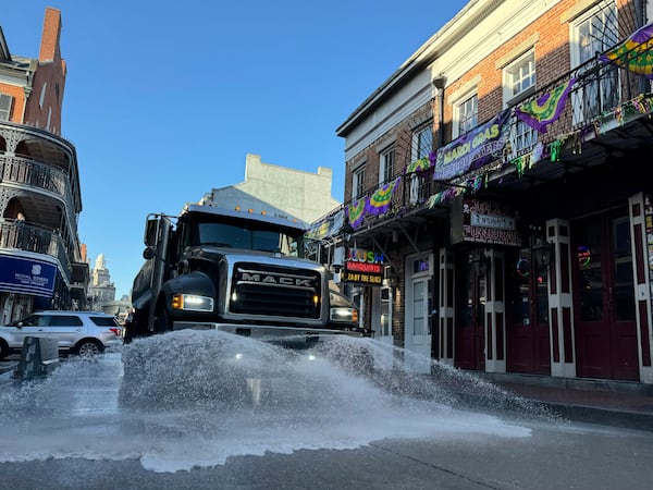 A water truck spraying lemon fragrance washes down Bourbon Street in New Orleans, the day after Mardi Gras, Wednesday, March 5, 2025. (AP Photo/Jack Brook)