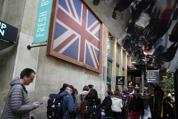 Travelers wait as Eurostar trains to London and all trains heading to northern France have been brought to a halt following the discovery of an unexploded bomb dating back to World War II near the tracks, Friday, March 7, 2025 at the Gare du Nord station in Paris. (AP Photo/Christophe Ena)