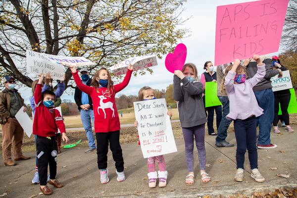 Parents and their children line along 10th Street NE near Piedmont Park on Sunday, Dec. 6, 2020, during a rally calling for the safe, immediate opening of all Atlanta and DeKalb County schools. (Steve Schaefer for The Atlanta Journal-Constitution)