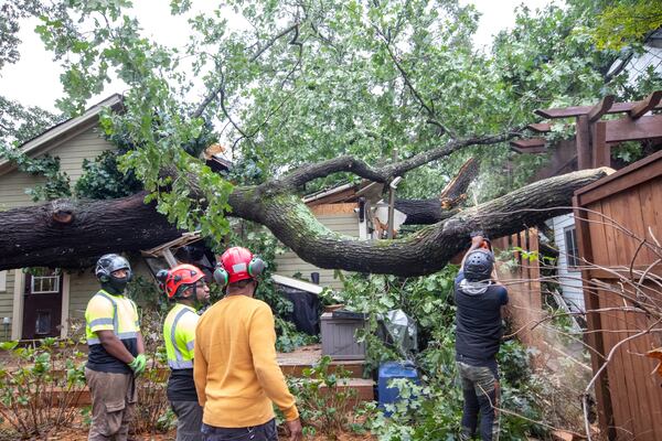 Dad’s Tree Service, including Markel Crear, from left, Mike Crear, Gary Cooper and Anthony Ray work to remove an oak tree from a Kirkwood home on Friday, Sept 27, 2024 after it fell on around 5:45 am during hurricane Helene.  Several homes were damaged in this area with multiple large oak trees falling in backyards. No one was hurt and residents are waiting for insurance adjusters to arrive.  (Jenni Girtman for The Atlanta Journal-Constitution)