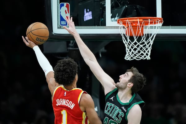 Boston Celtics' Luke Kornet, right, defends against a shot by Atlanta Hawks' Jalen Johnson (1) during the first half of an NBA basketball game, Saturday, Jan. 18, 2025, in Boston. (AP Photo/Robert F. Bukaty)