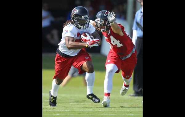 073115 FLOWERY BRANCH: Falcons running back Devonta Freeman breaks away from linebacker Nate Stupar for yardage on the first day of training camp on Friday, July 31, 2015, in Flowery Branch. Curtis Compton / ccompton@ajc.com