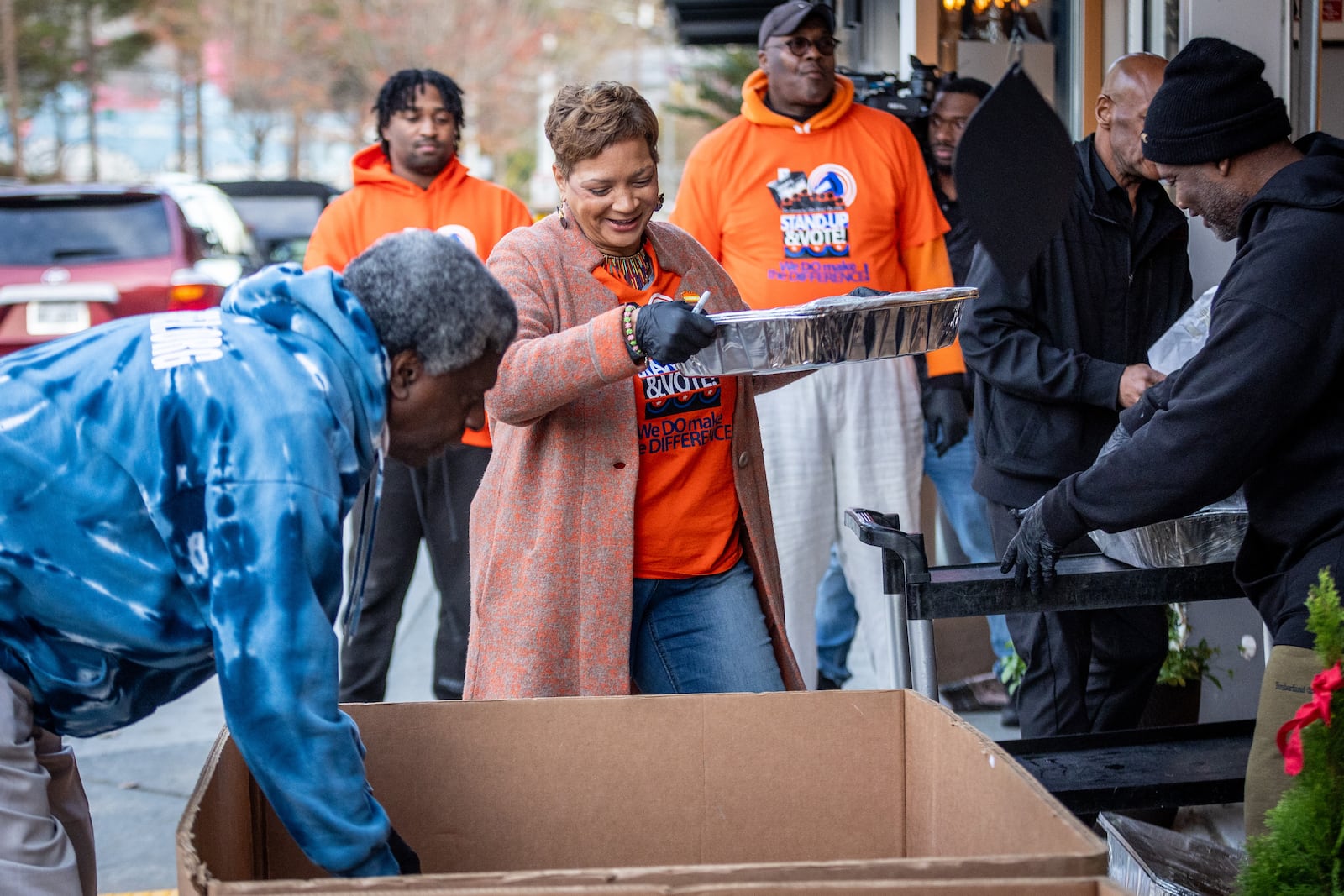 Beborah Scoot (Center) loads trays of food into boxes that will be loaded onto a truck and delivered to people around Atlanta on Thursday, November 23, 2023.  (Steve Schaefer/steve.schaefer@ajc.com)