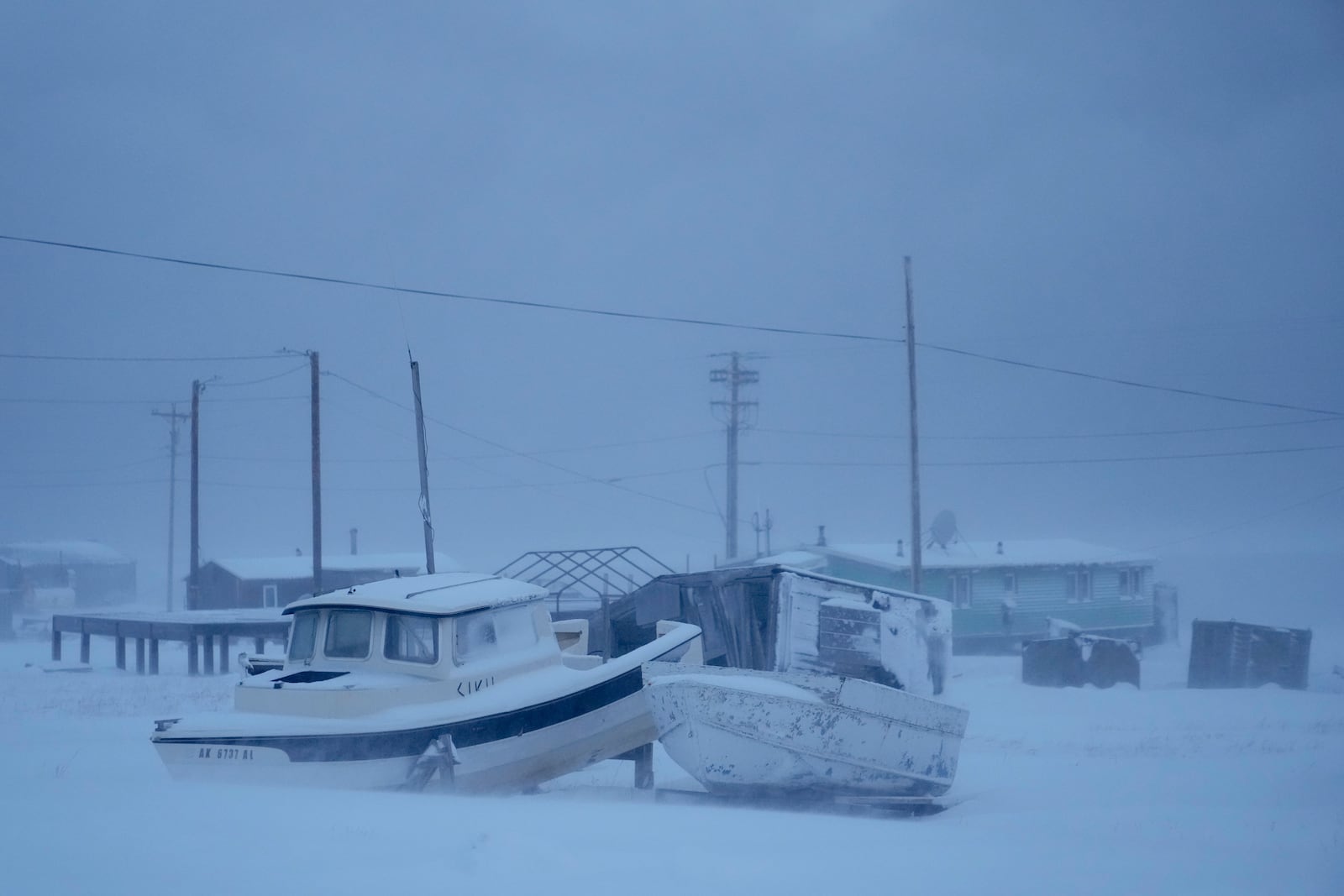 A pair of small boats sit in a blizzard in Kaktovik, Alaska, Thursday, Oct. 17, 2024. (AP Photo/Lindsey Wasson)