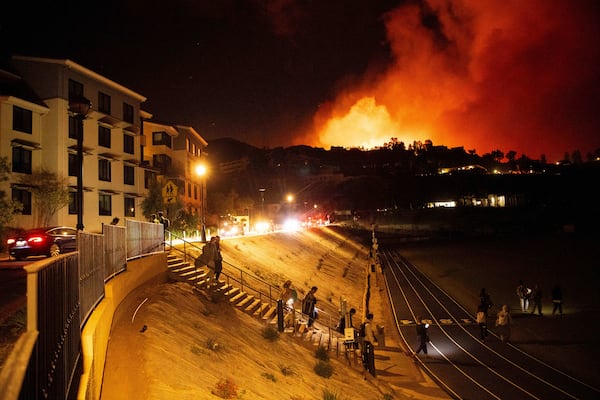 Students evacuate from Pepperdine University as the Franklin Fire burns in Malibu, Calif., on Tuesday, Dec. 10, 2024. (AP Photo/Ethan Swope)