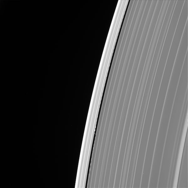 Image of Saturn's outer A ring featuring the small moon Daphnis and the waves it raises in the edges of the Keeler Gap.