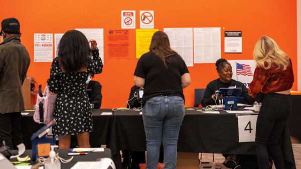 Voters receive instruction from polling station volunteers, Thursday, Oct. 31, 2024, in Atlanta. (AP Photo/Jason Allen)