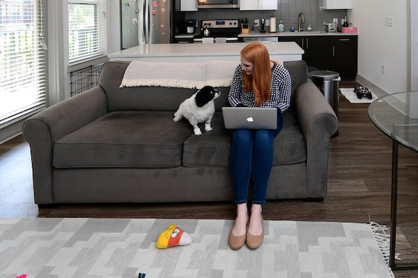 Kristen Settlemire, attorney, is getting settled into her new apartment with her dog Chloe, a five year old Shih Tzu mix, in the Battery in Cobb County. Settlemire moved from living near her work in the city center after being allowed to work from home due to COVID 19, and is saving around $600 per month. JOHN AMIS FOR THE ATLANTA JOURNAL-CONSTITUTION