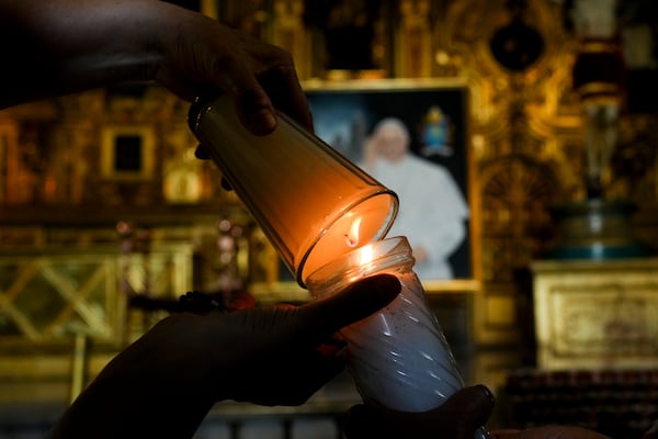 Parishioners light candles while praying for the health of Pope Francis at the Metropolitan Cathedral in Mexico City, Thursday, Feb. 27, 2025. (AP Photo/Marco Ugarte)