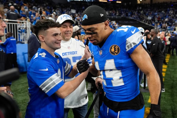 Jacob Rinehart shakes hands with Detroit Lions wide receiver Amon-Ra St. Brown (14) before an NFL football game against the Chicago Bears, Sunday, Nov. 17, 2024, in Detroit. (AP Photo/Carlos Osorio)