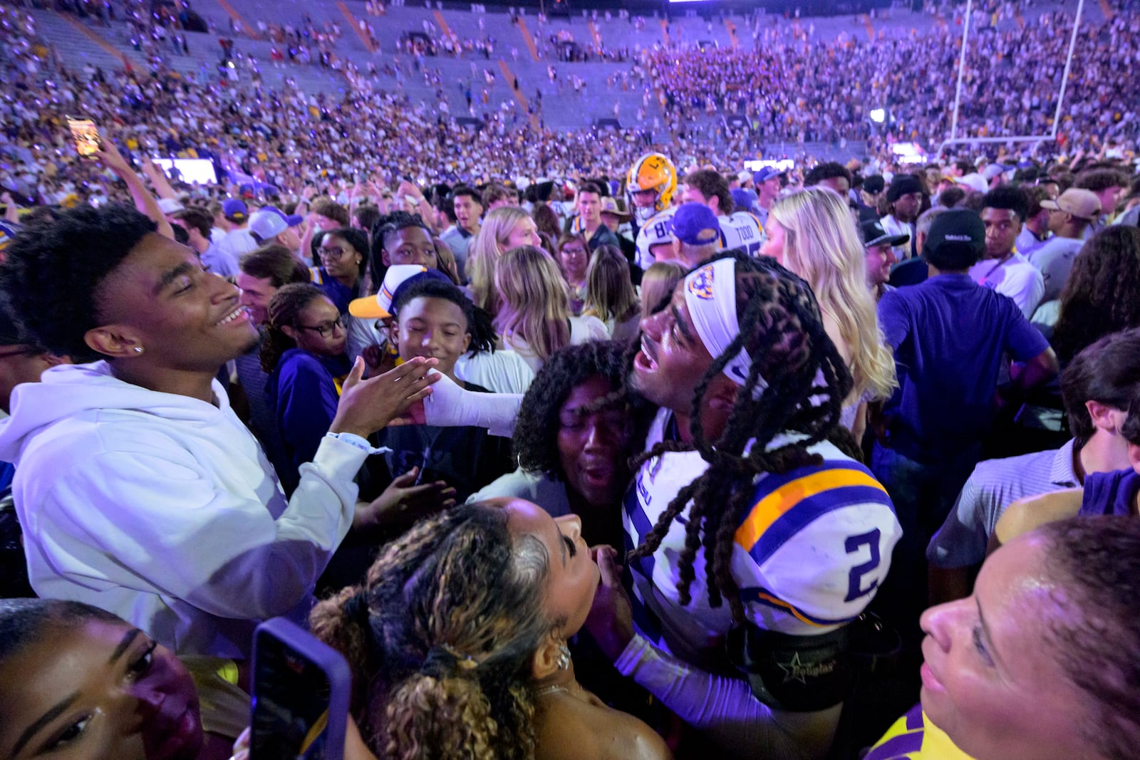 LSU safety Jardin Gilbert (2) celebrates with LSU fans after they rushed the field after the team's overtime victory over Mississippi in an NCAA college football game in Baton Rouge, La., Saturday, Oct. 12, 2024. (AP Photo/Matthew Hinton)