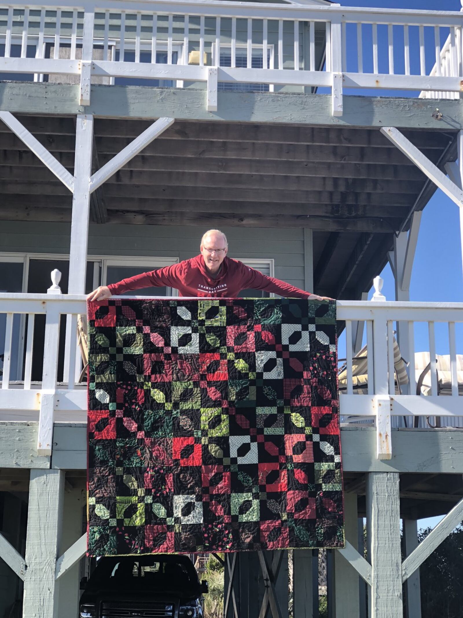 Judge Emily Powell’s husband Tony shows off one of the handmade quilts she was known for making.