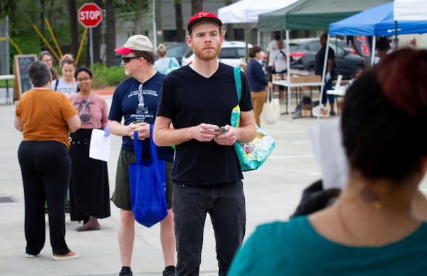 Shoppers stand in line waiting to pick up fresh bread at the Grant Park Farmers Market in Atlanta on March 29, 2020. STEVE SCHAEFER / SPECIAL TO THE AJC